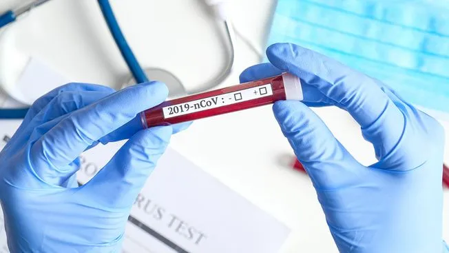 Researcher looking a vile of coronavirus