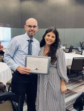 Photo of Matthew Quiroz holding thesis award and Lauren Schnell