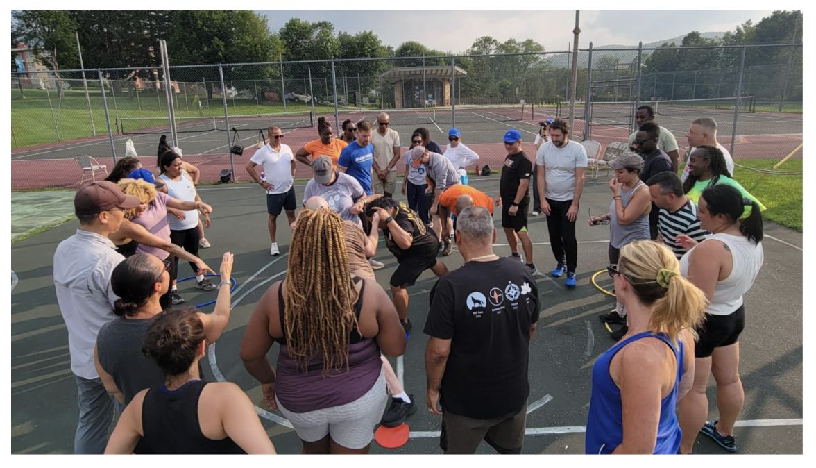 Gray Fellows gather for an activity on a playground blacktop