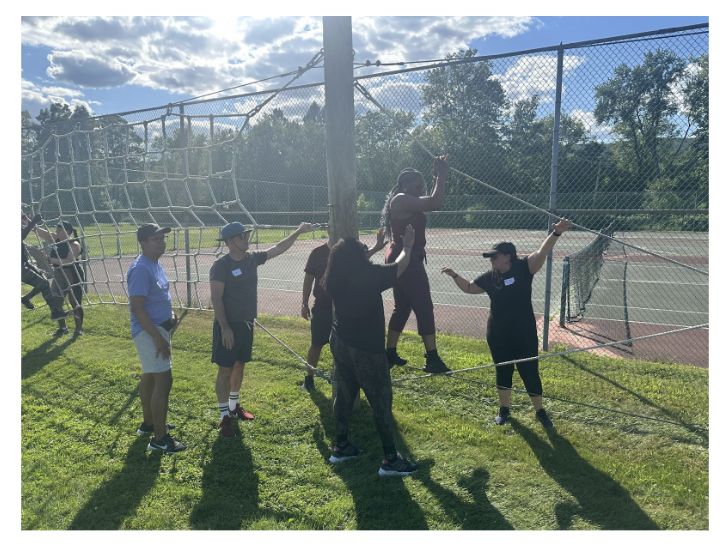 Gray Fellows participate in an outdoor activity involving ropes.
