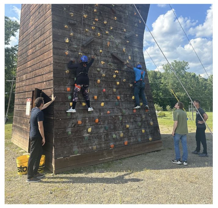 Gray Fellows climb an outdoor rock climbing wall.