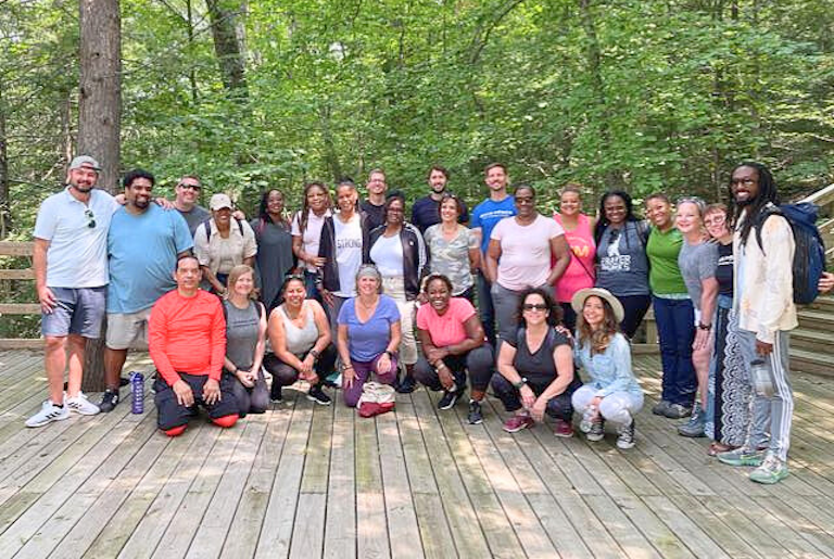 The Gray Fellows 2021 to 2022 "Polaris" cohort gathers on an outdoor deck in a forrest.