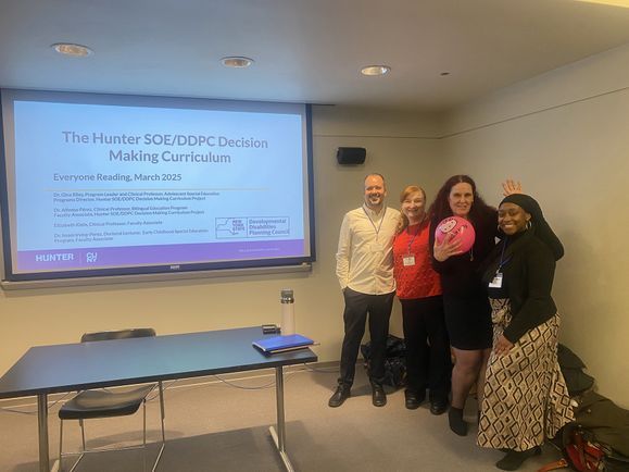 Aflonso Perez, Gina Riley, Eliizabeth Klein and Imani Irving Perez stand in front of their presentation.